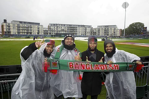Bangladesh cricket fans display their allegiance, as they stand in the rain during the ICC Cricket World Cup group stage match at the County Ground in Bristol. (Photo | AP)