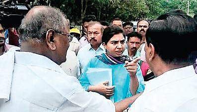 Shivamogga City Corporation Commissioner Charulata Somal and MLC Ayanur Manjunath have an argument in Shivamogga on Tuesday. D C Thammanna looks on | Express