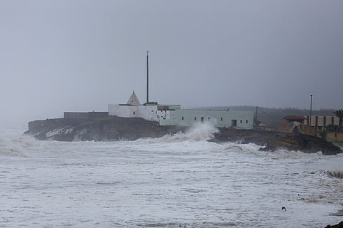 A huge wave hits the wall of a temple along the seashore during high tide at Veraval in Gir Somnath on 13 June 2019. (Photo | PTI)