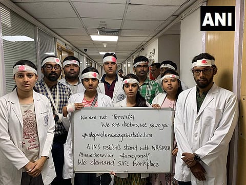 Resident doctors at the AIIMS and Safdarjung Hospital worked with bandages on their heads in a symbolic protest on Thursday and called for the suspension of all non-emergency services. (Photo | ANI)