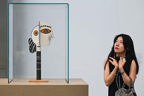 A woman looks at the artwork entitled 'Head of Woman' by Pablo Picasso at an art gallery in Beijing on June 14, 2019. (Photo | AFP)
