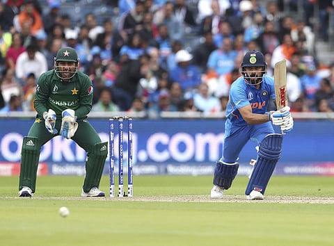 Pakistan's captain Sarfaraz Ahmed, left, reacts after India's captain Virat Kohli, right, played a shot during the Cricket World Cup match between India and Pakistan at Old Trafford in Manchester. (Photo | AP)