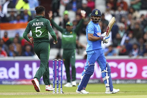 India's captain Virat Kohli, right, leaves the pitch after he is caught by Pakistan's captain Sarfaraz Ahmed, center, off the bowling of Pakistan's Mohammad Amir, left, during the Cricket World Cup match between India and Pakistan. (Photo | AP)