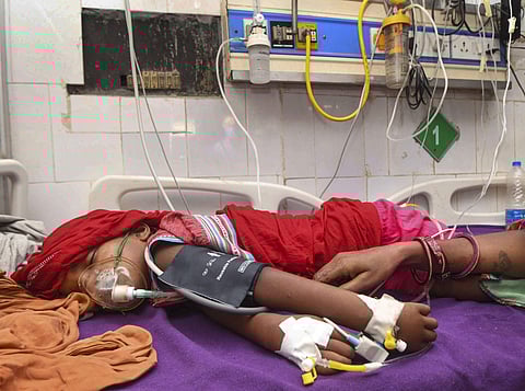 A child shows symptoms of Acute Encephalitis Syndrome AES undergoes treatment at a hospital in Muzaffarpur. (Photo | PTI)