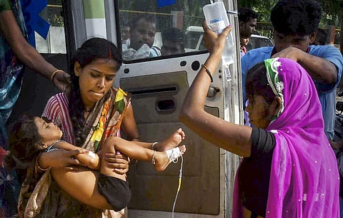A woman carrying a child showing symptoms of Acute Encephalitis Syndrome AES arrives at Shri Krishna Medical College and hospital for treatment in Muzaffarpur Sunday June 16 2019. | PTI