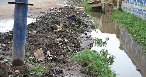 Silt removed from drain and dumped along it at Mission Road on Monday. (Photo | EPS)