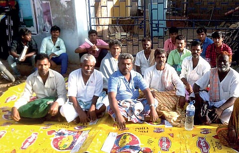 Villagers wait in front of SBI Bank premises for their Aadhaar cards, in Ron, Gadag district of Karnataka. (Photo | EPS)