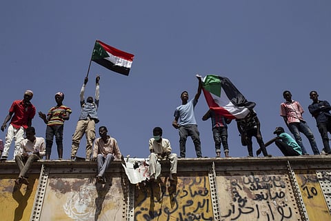 Sudanese protesters wave national flags at the sit-in outside the military headquarters, in Khartoum (File photo| AP)