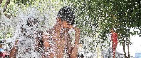 A young boy beats the heat at a tubewell on a hot Saturday in New Delhi. The weatherman has forecast heat wave in the next few days | Shekhar Yadav