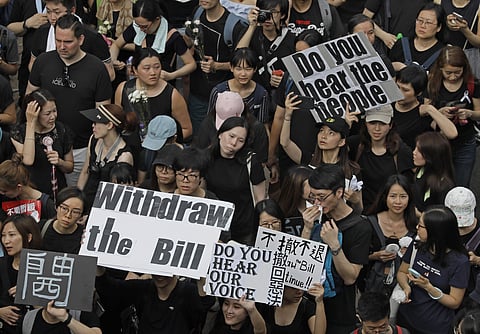 Protesters holding posters and flowers march on the streets to protest against the unpopular extradition bill in Hong Kong (File Photo | AP)