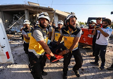 Members of the Syrian Civil Defence, also known as the 'White Helmets', carry away a body on a stretcher following a reported government air strike in the village of Benin, about 30 kilometres south of Idlib in northwestern Syria (Photo|AFP)