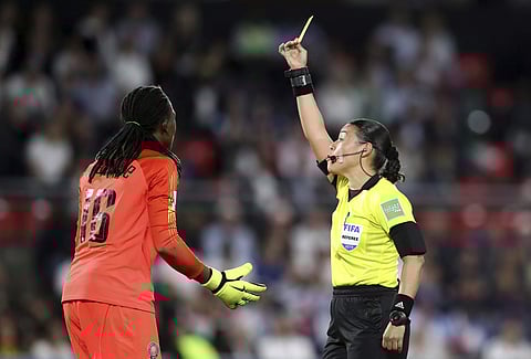 Nigeria goalkeeper Chiamaka Nnadozie, left, is shown a yellow card by referee | AP