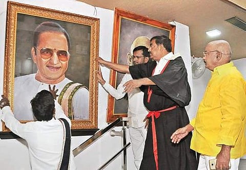 Mayor Koneru Sridhar helps in putting back the portrait of former Andhra CM NT Rama Rao in Council Hall in Vijayawada on Saturday. (Photo | Prasant Madugula, EPS)