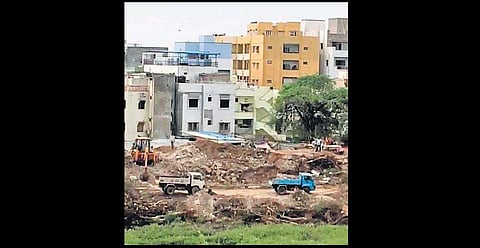 Earth movers and trucks spotted working on the periphery of the Devunikunta lake bed in Asifnagar. (Photo | EPS)