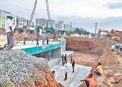 Precast reinforced concrete cement boxes being placed between Guduvanchery and Vandalur railway station on Saturday | Express