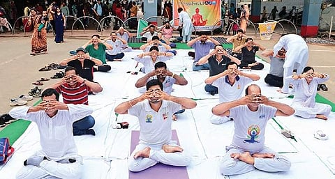 Participants performing Yoga at Bhubaneswar Railway Station. ( Photo | EPS)