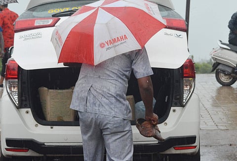 MLA’s gunman carries the shoes in Hubballi on Sunday. (Photo | D Hemanth , EPS)