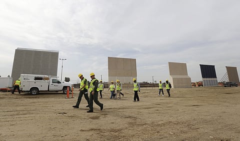People pass border wall prototypes as they stand near the border with Tijuana, Mexico, in San Diego. (File Photo | AP)