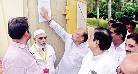 TDP leaders look at the notice pasted by CRDA officials on the wall of party’s national president N Chandrababu Naidu’s residence at Undavalli. (Photo | EPS