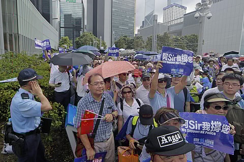 Pro-China's supporters hold Chinese flags and placards read 'We support HK police' during a rally outside Legislative Council Complex in Hong Kong. (Photo | AP)