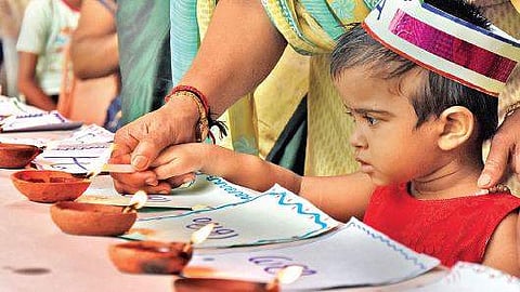 A newcomer from the welfare council lighting an earthen lamp as part of the Praveshanolsavm at Government Model LPS, Thycaud on Thursday B P Deepu