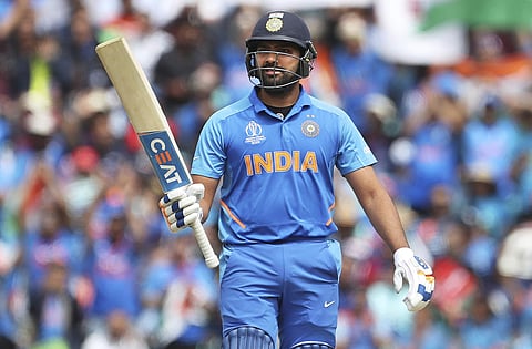 Rohit Sharma raises his bat to celebrate scoring fifty runs during the Cricket World Cup match between Australia and India at The Oval (Photo | AP)