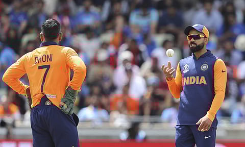 India's captain Virat Kohli, right, speaks with teammate Mahendra Singh Dhoni during the Cricket World Cup match between India and England in Birmingham. (Photo | AP)