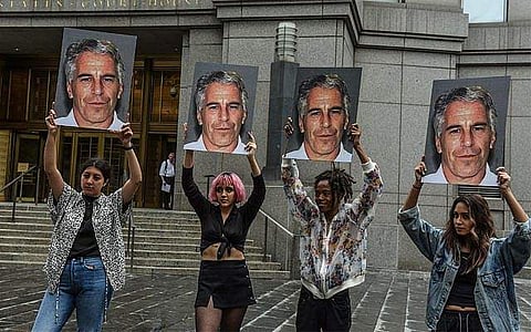 Protesters hold up signs of Jeffrey Epstein in front of the federal courthouse on July 8, 2019, in New York City. (Photo | AFP)