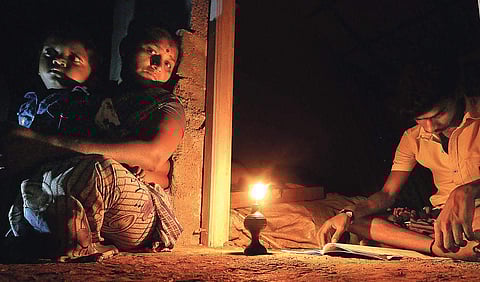 A boy studies under the light of kerosene lamp at a house in Killakku Theru of Vadpatti Taluk in Madurai | k k sundar