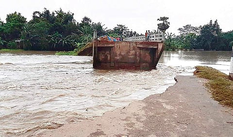 A damaged bridge washed away by the floods at Lahorighat, in Morigaon, on Saturday. Almost all rivers in Assam are in spate. | (File | PTI)