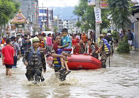 Nepalese army men rescue a sick boy from a flooded area in Bhaktapur, Nepal. he flooding was caused by overflowing of the Hanumante River following heavy rain. ( Photo | AP)