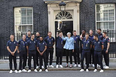 Britain's Prime Minister Theresa May smiles as she stands with England cricket captain Eoin Morgan, members of the team and the trophy after England won the Cricket World Cup, outside Downing Street in London. (Photo | AP)