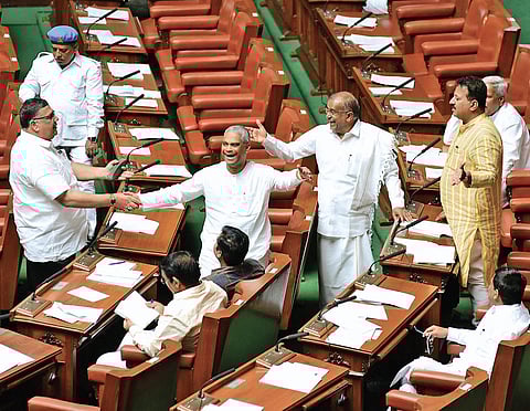 Minister G T Devegowda and Congress MLA Tanveer Sait exchange greetings with BJP MLAs before the Assembly session at Vidhana Soudha in Bengaluru on Monday (Photo | Vinod Kumar T, EPS)