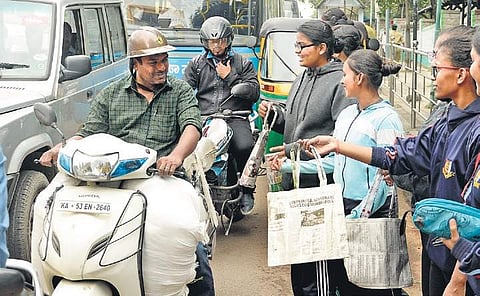 A group of college students requests motorists to use environment-friendly paper bags, instead of plastic bags, near KR Circle in Bengaluru on Wednesday (Photo | Shriram BN, EPS)