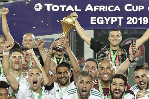 Algeria's captain Riyad Mahrez, center, holds up the trophy at the end of the African Cup of Nations final soccer match between Algeria and Senegal in Cairo International stadium in Cairo, Egypt. (Photo | AP)
