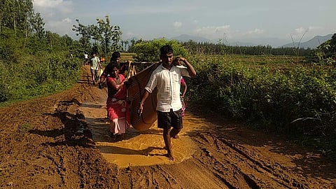 Family members carry Janapareddi Devi in a sling bag as an ambulance counldn't reach her village because of the muddy road in Visakhapatnam agency. (Photo | EPS)