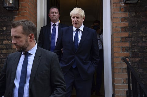 Conservative Party leadership contender Boris Johnson, right, leaves his office in London. (Photo | AP)