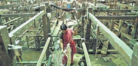 File picture of a worker cleaning a loom at Chendamangalam Albin Mathew