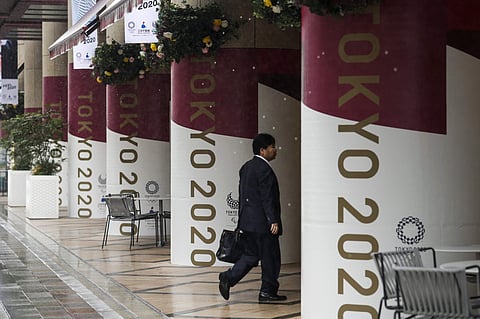 A man walks into a building decorated with Tokyo 2020 banners. (Photo | AP)