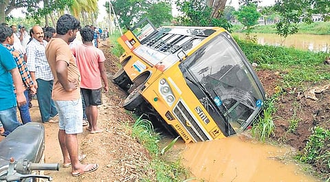 Locals gather at the site where a school bus fell into a canal at Thethali village in West Godavari district on Wednesday | Express