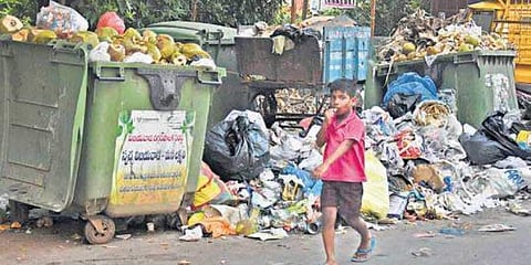 A boy walking past a garbage heap in Vijayawada (File Photo | EPS)