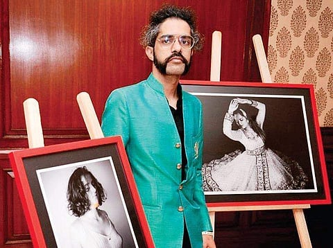 Photographer Augustus Lightwriter with his photographs from his show