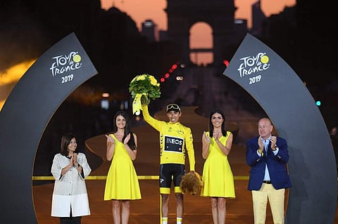 Colombia's Egan Bernal (C) celebrates his overall leader's yellow jersey on the podium next to Paris' mayor Anne Hidalgo (L) at the end of the 21st and last stage of the 106th edition of the Tour de France cycling race between Rambouillet and Paris Champs
