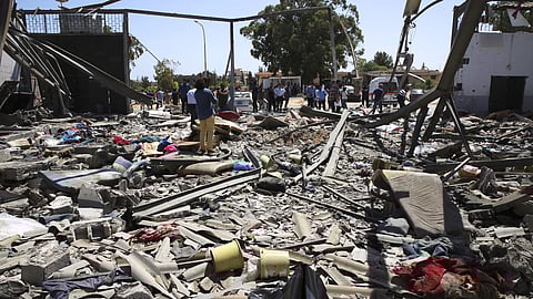 Debris covers the ground after an airstrike at a detention center in Tajoura | AP