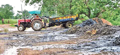 A tractor dumps silt lifted from drains on Mahanadi river bed | Express