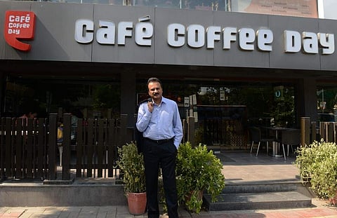 VG Siddhartha in front of a Cafe Coffee Day. (Photo | PTI)