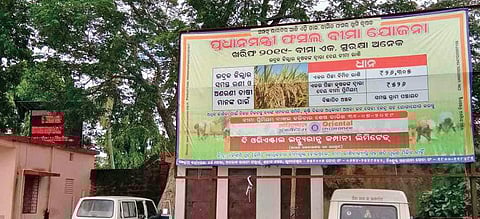 An awareness poster on PMFBY put up at Jagatsinghpur town (Photo |EPS)