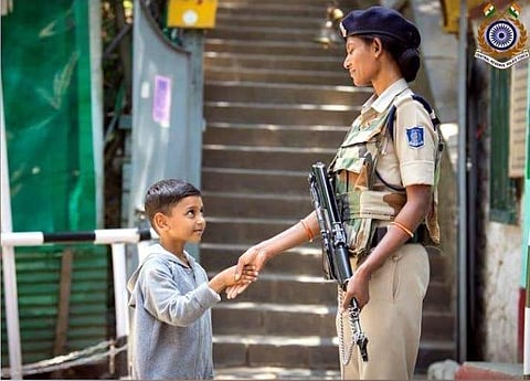 A woman CRPF personnel shakes hands with a Kashmiri child (IANS photo)