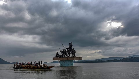 A passenger boat ferries across people while dark clouds hover over river Brahmaputra in Guwahati.