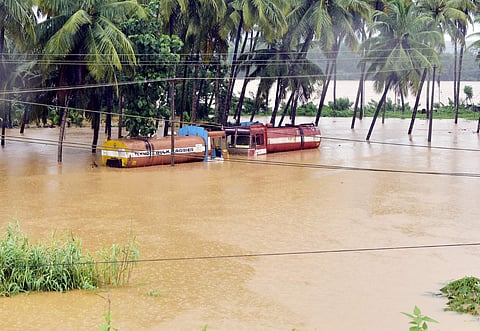 Two parked trucks submerged in flood water near Bramarakutlu in B C Road on Saturday. | (Rajesh Shetty | EPS)